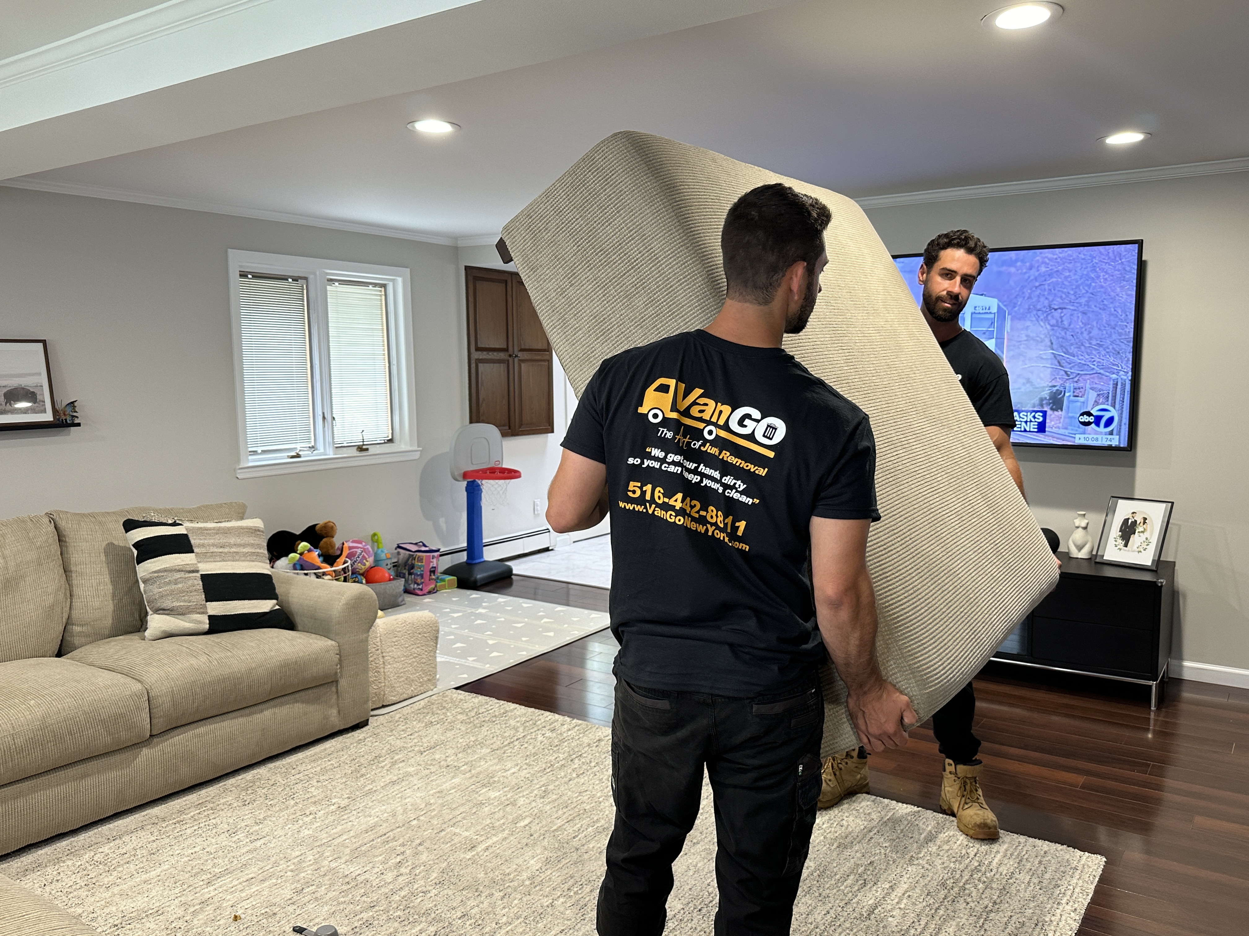 Junk removal experts carrying furniture.